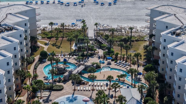 Ein Resort mit Poolbereich, Strandstühlen und Blick aufs Meer.