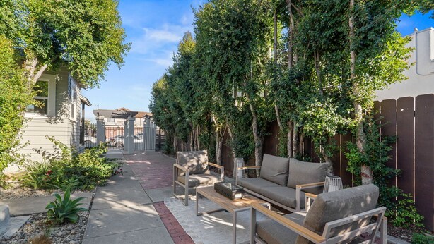 A patio with outdoor furniture, a pathway, and a fence.