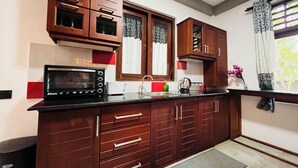 Una cucina con mobili in legno, un forno a microonde e un lavello.