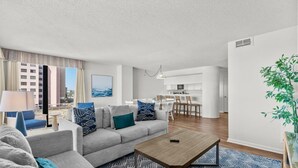 A modern living room with a sofa, coffee table, and dining area. - Beachfront Breeze @ Sea Castle North Myrtle Beach (North Myrtle Beach)