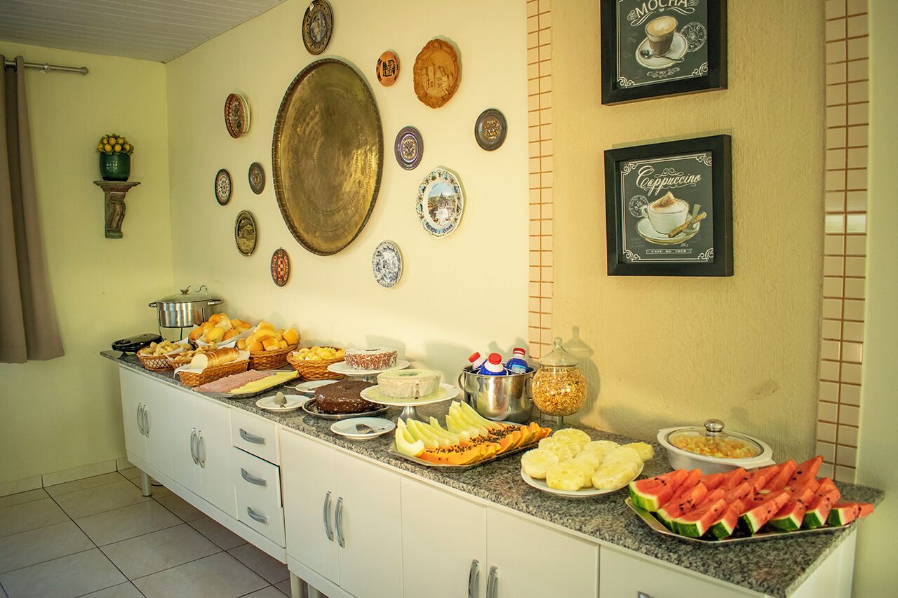 A buffet table with various food items and decorative plates on the wall.