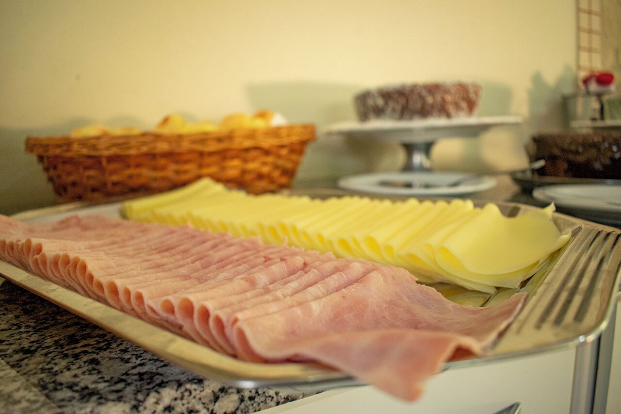 Een buffet met plakjes ham en kaas.