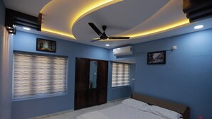 Ein Schlafzimmer mit Bett, Deckenventilator und Klimaanlage.