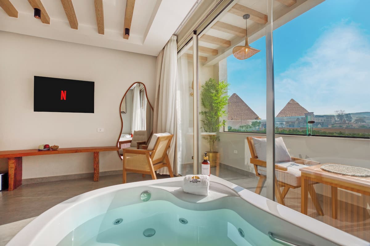 Une chambre moderne avec une grande fenêtre, un banc en bois, un jacuzzi et un logo Netflix sur le mur.