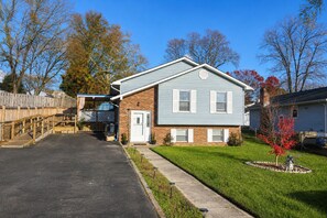A two-story house with a garage, a covered porch, and a well-maintained lawn. - Modern Halethorpe Home. Sleeps 8. 4 Beds. Near BWI, UMBC & Baltimore (halethrope)