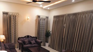 A living room with a sofa set, a coffee table, and curtains. - Sant Niwas Shahpur 3BHK Villa (Mohali)