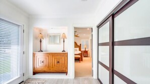 A hallway with a wooden cabinet, two lamps, and a patterned rug. - New Listing discount Book Now Waterfront Escape• 3BR • Hot Tub • Gourmet Kitchen (Marco Island)