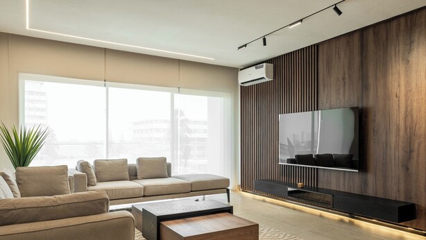 A modern living room with a sofa, coffee table, and a flat-screen TV mounted on a wooden wall. - Coral Luxe Suite - Spacious  Luxury 3 Bed Waterfront View in quiet VI cul-de-sac (Lagos)