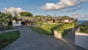 A modern house with a covered patio, a well-maintained lawn, and a stone pathway leading to the entrance. - Villa Rose by Elite Havens (The Bukit)