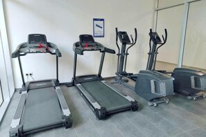 A fitness area with treadmills, an elliptical, and a stationary bike. - ABHome [Flora Suite] Midas Seri Alam #Mall #JB (Plentong)