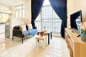 A modern living room with a sofa, coffee table, TV, and a balcony view. - ABHome [Flora Suite] Midas Seri Alam #Mall #JB (Plentong)