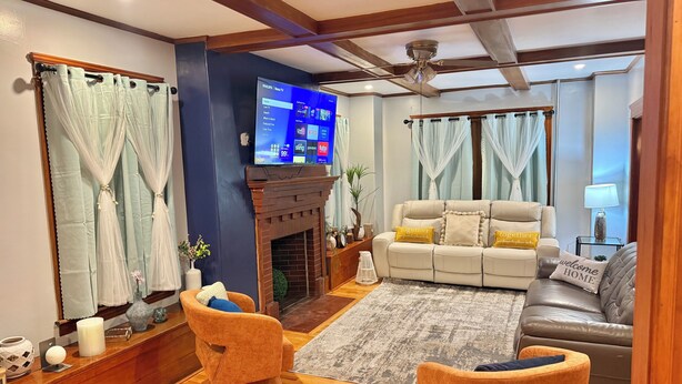 Una sala de estar con chimenea, televisor y sofá.