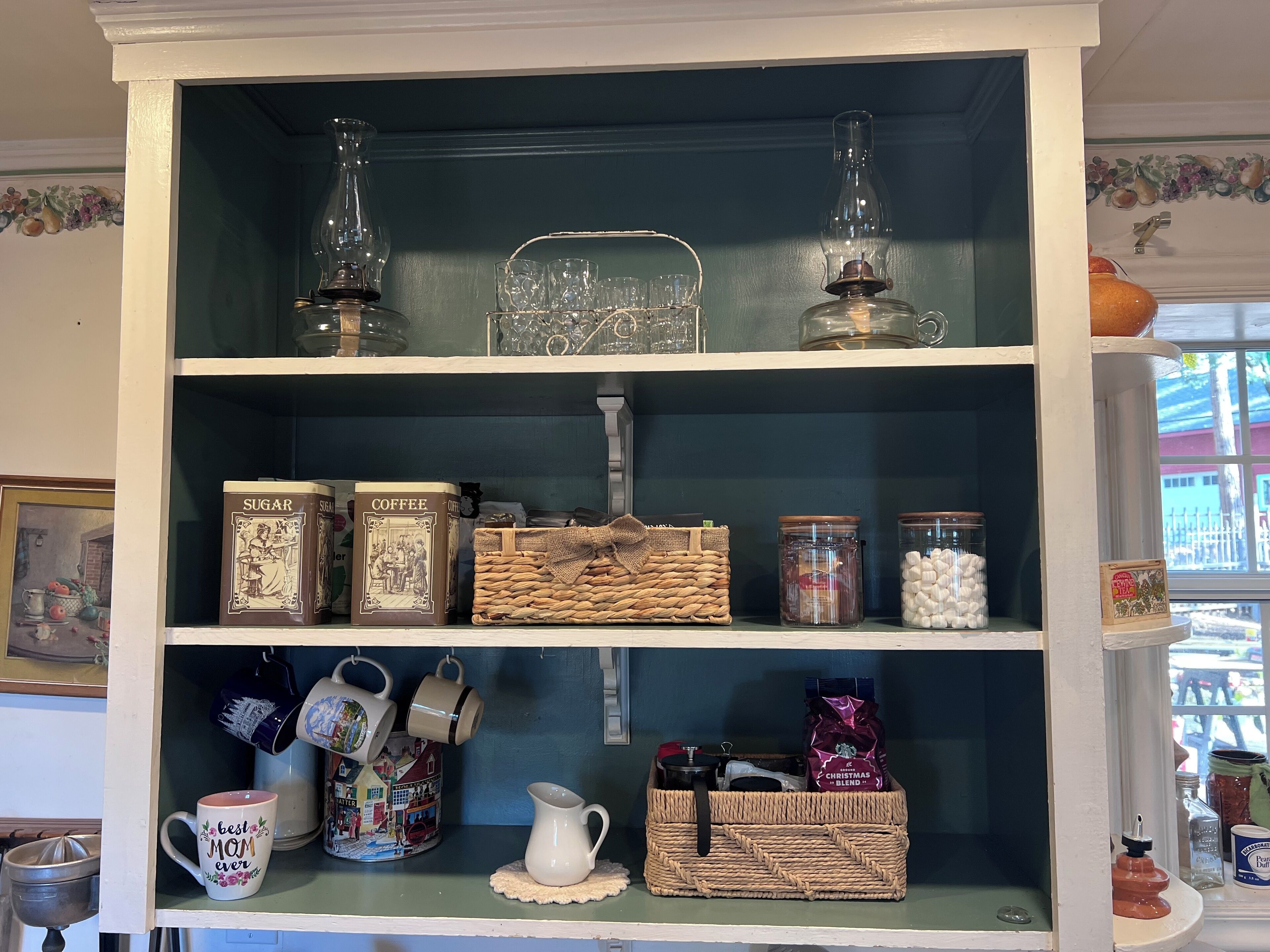 A shelf with sugar, coffee, and a wicker basket.