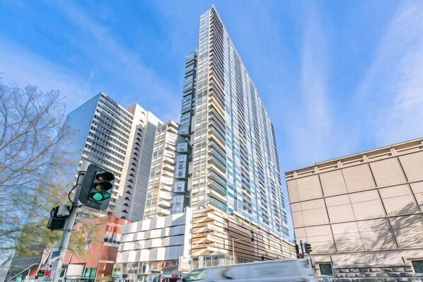 A tall building with a modern architectural design, a traffic light, and a clear sky. - lvl42 2B APT with Free Parking in CBD (Melbourne)