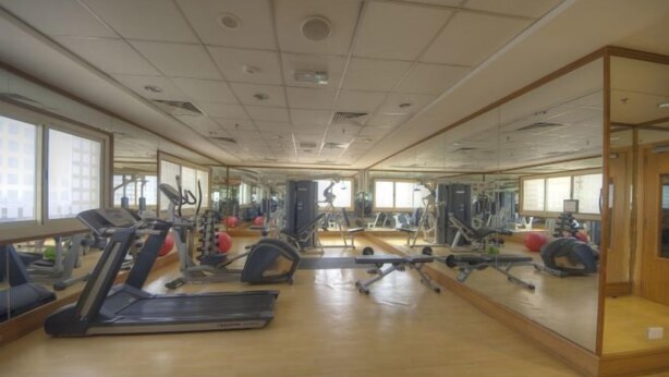 A gym with treadmills, elliptical machines, and free weights. - City Stay Grand Hotel Apartments - Al Barsha (Dubai)