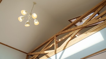 A room with exposed wooden beams and a ceiling light fixture.