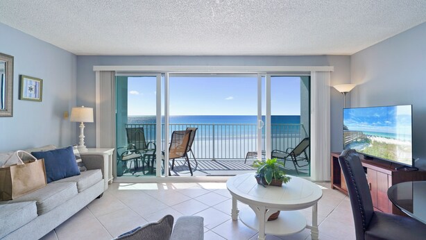 A room with a balcony, a sofa, a coffee table, and a TV. - Enjoy Stunning Gulf Front Cabana Club 304! Private balcony with beautiful views! (Destin)