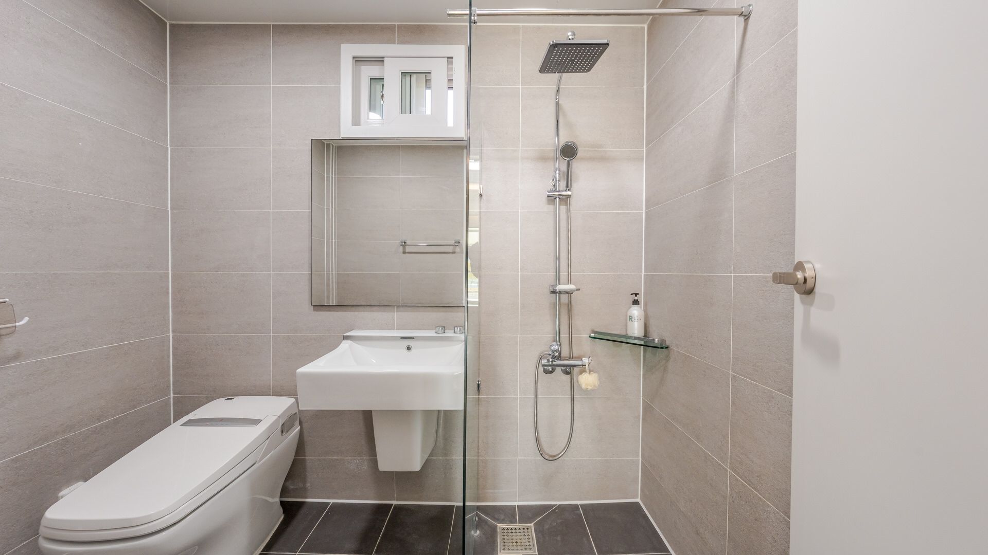 Un baño moderno con inodoro, lavabo y ducha.