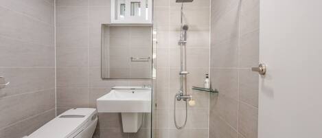 Un baño moderno con inodoro, lavabo y ducha.