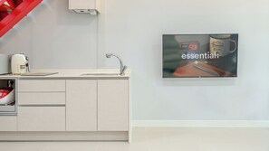 Een moderne keuken met een ingebouwde gootsteen, een koffiezetapparaat en een ingelijste advertentie aan de muur.
