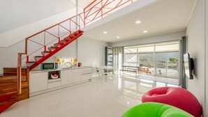 Una cocina moderna con una escalera de madera y un comedor con un ventanal grande.