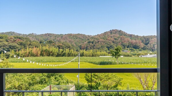 A view of a lush green landscape with a clear sky, featuring a series of light bulbs strung across the scene. - Gyeongju Starlight Pension (Gyeongju)
