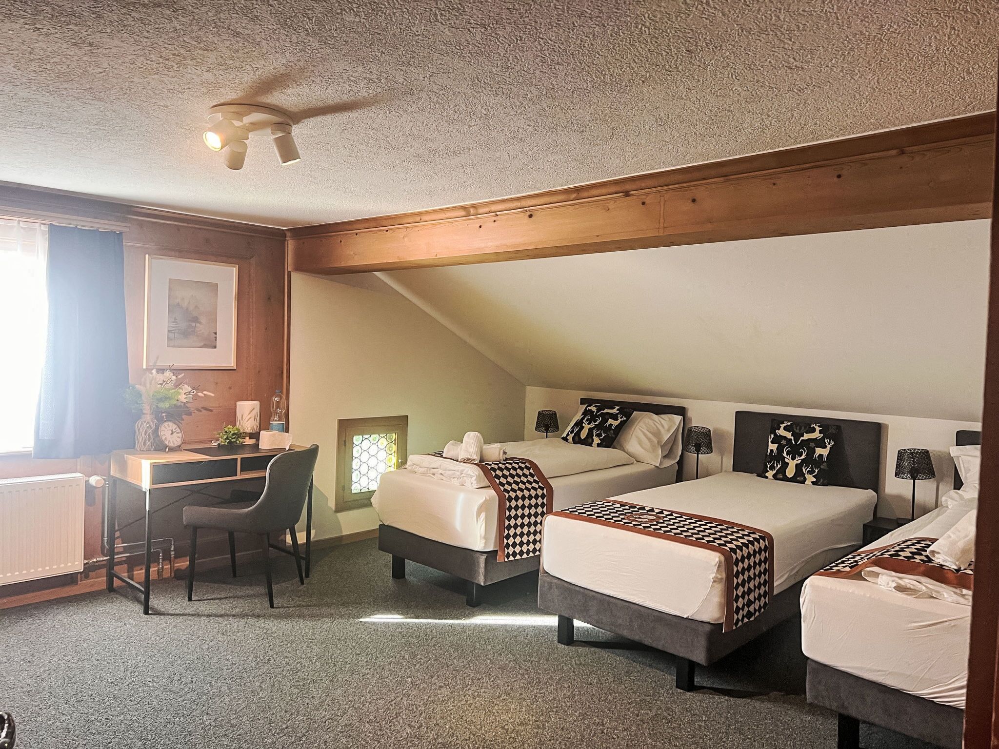 Une chambre d’hôtel avec deux lits, un bureau et une chaise.