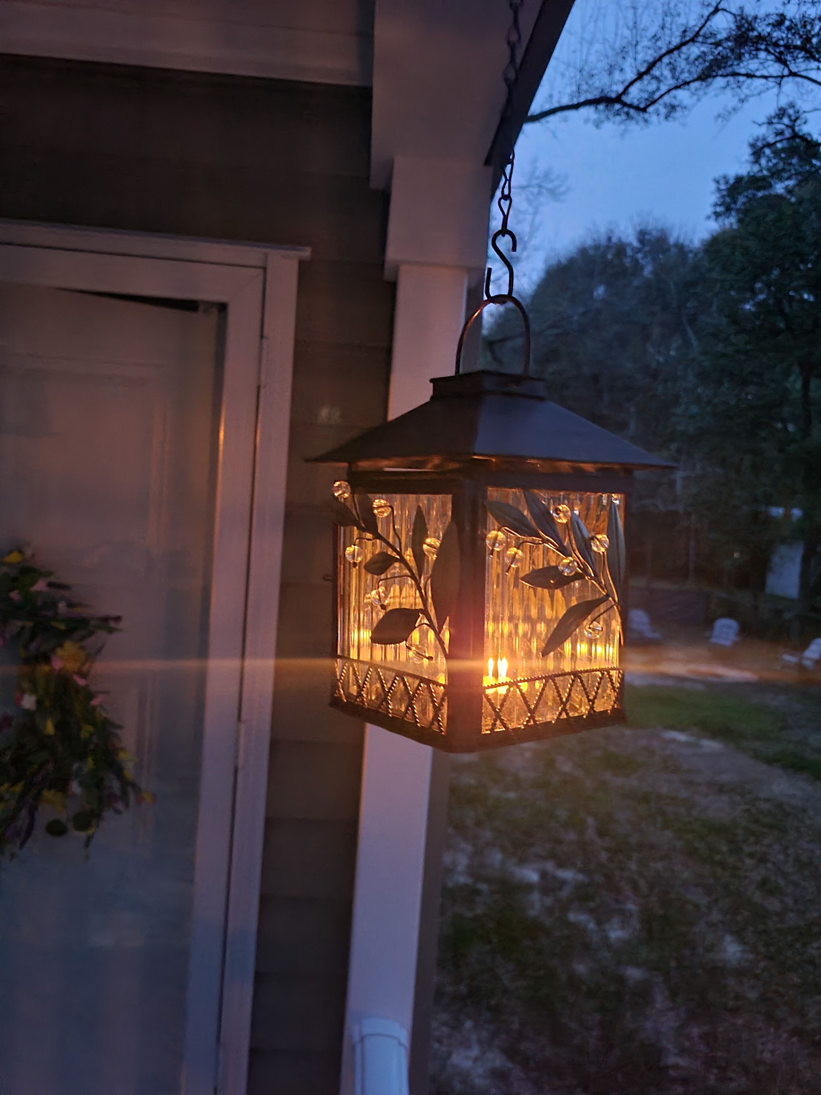 A lantern hanging on a porch with a clear view of the surrounding area.