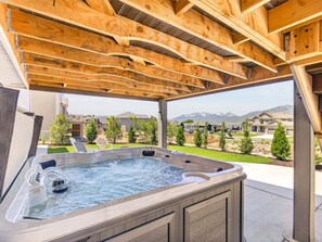 Ein Whirlpool unter einer hölzernen Pergola mit Blick auf eine Wohngegend.