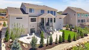 A multi-story residential building with a covered patio, outdoor seating, and a landscaped garden. - Deer Valley Views, 5br Sleeps 16, Hot Tub, Theater (Heber City)