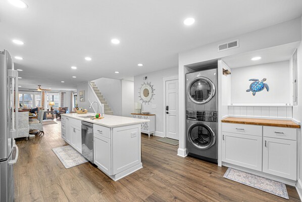 A modern kitchen with white cabinetry, a central island, and built-in appliances. - 306 Tennismaster Villas @ Shipyard | Multiple Balconies | Walk to Tennis | Community Pool (Hilton Head Island)