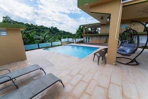 A swimming pool with a view of lush greenery, a hanging chair, and a bench area. - Villa Verde - Scenic Views of El Yunque Rainforest (R ío Grande)