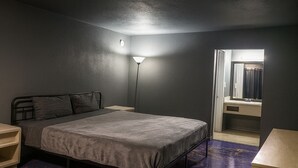 Une chambre à coucher avec un lit, une table de chevet, une lampe et un miroir.