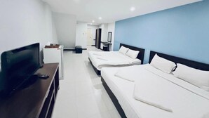 Una habitación de hotel con dos camas, un televisor y un escritorio.