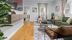 Un salon moderne avec un canapé, une table basse et un téléviseur fixé au mur.