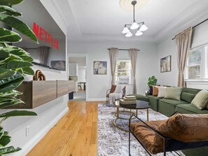 Ein modernes Wohnzimmer mit Sofa, Couchtisch und Wandfernseher.