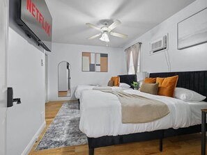 Ein Hotelzimmer mit Bett, Deckenventilator, Fernseher und Tür.