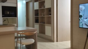 Een moderne keuken met een eethoek, inbouwkasten en een televisie aan de muur.