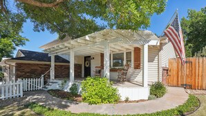 A house with a covered porch, a brick exterior, and a wooden fence. - The Rustic Retreat (Castle Rock)