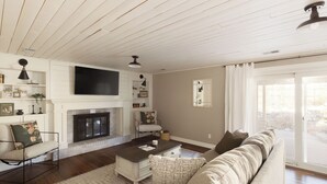 A living room with a fireplace, a sofa, a coffee table, and a television. - The Rustic Retreat (Castle Rock)