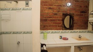 A bathroom with a tiled floor, a sink with a mirror above it, and a towel rack. - Colonial-Styled Hotel Villa in Ataco at 1,200 AMSL - 12 Rooms & Cabins available (Concepción de Ataco)