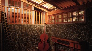 A room with a stone wall, a wooden bench, and a wooden cabinet. - Colonial-Styled Hotel Villa in Ataco at 1,200 AMSL - 12 Rooms & Cabins available (Concepción de Ataco)