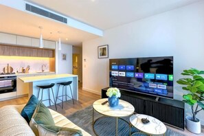 Una sala de estar moderna con un sofá, una mesa de centro y un televisor.