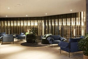 Ein stilvoller Aufenthaltsbereich mit Sofas und Sesseln, die um einen Couchtisch gruppiert sind.
