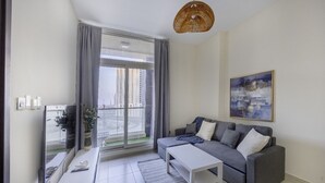 Un salon moderne avec un canapé, une table basse et une grande fenêtre avec des rideaux.