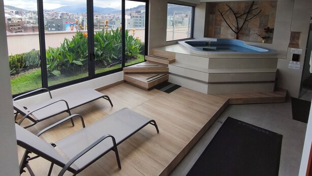 A modern interior with a large skylight, a hot tub, and a view of the city.