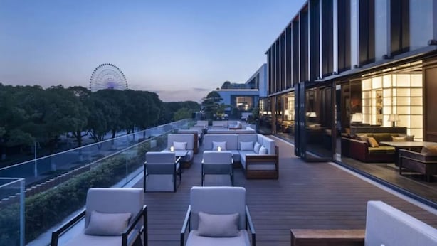 A rooftop terrace with outdoor seating and a view of a Ferris wheel. - Hilton Garden Inn  (Suzhou)