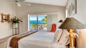 A bedroom with a bed, a ceiling fan, a view of the ocean, a chair, and a lamp. - 3BR Gulf-Front Luxury with Panoramic Views (Englewood)
