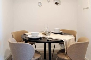 Ein Essbereich mit einem runden Tisch, vier Stühlen und einer weißen Tischdecke.