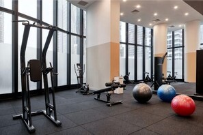 A gym with exercise equipment, large windows, and a high ceiling. - lvl35 Uno Melbourne CBD with City View (Melbourne)